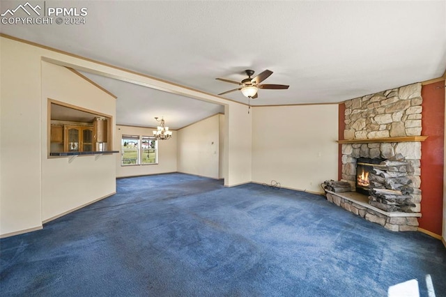 unfurnished living room featuring lofted ceiling, ceiling fan with notable chandelier, a fireplace, ornamental molding, and dark colored carpet