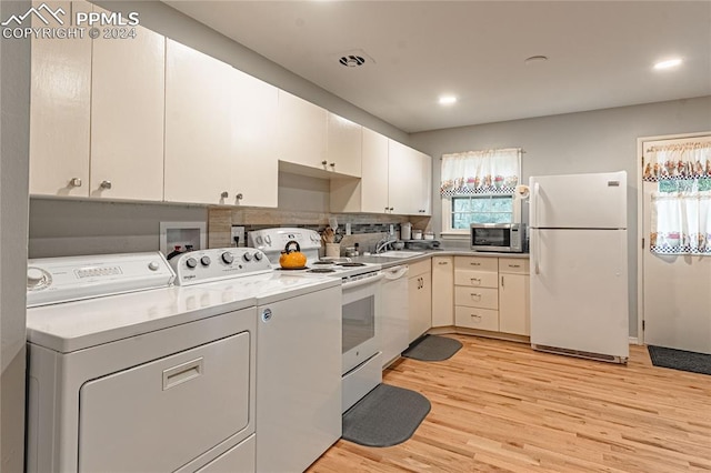 kitchen with separate washer and dryer, light hardwood / wood-style flooring, plenty of natural light, and white appliances