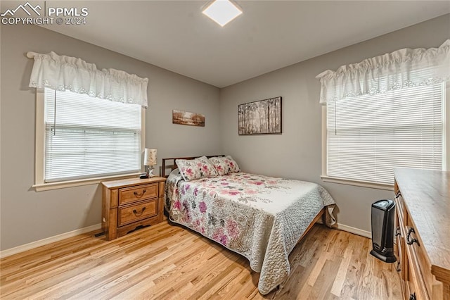 bedroom with light wood-type flooring and multiple windows