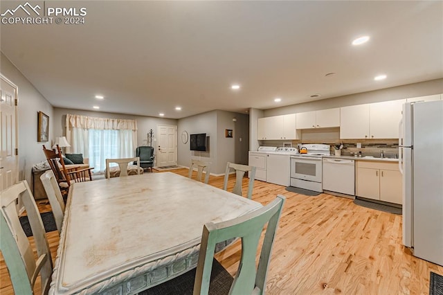 dining space featuring separate washer and dryer, sink, and light hardwood / wood-style flooring