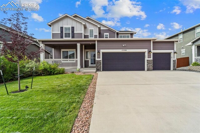 craftsman-style house with a garage, a porch, and a front yard