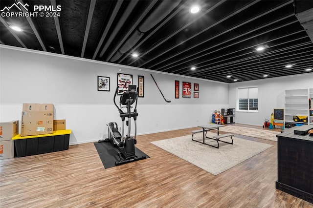 workout area with ornamental molding and hardwood / wood-style flooring