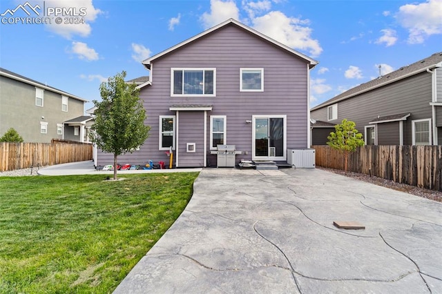 back of house with a patio area and a yard