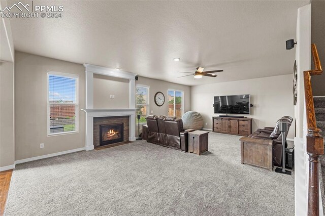 carpeted living room with ceiling fan