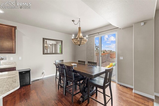 dining area with hardwood / wood-style floors and a chandelier