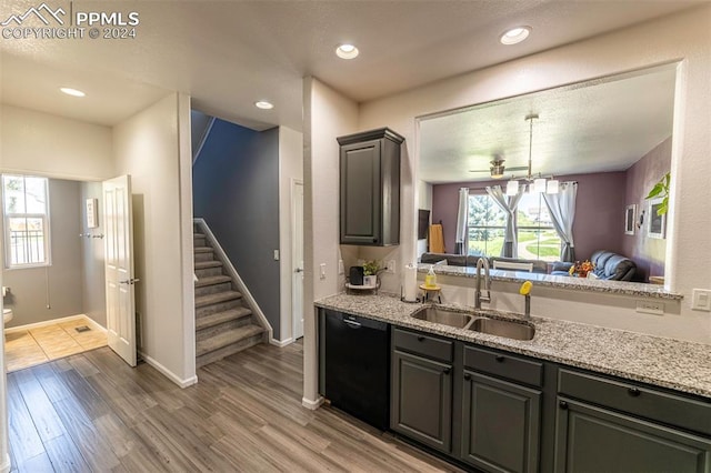 kitchen with sink, light stone counters, dishwasher, and wood-type flooring