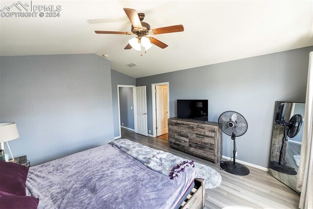 bedroom featuring ceiling fan, wood-type flooring, and lofted ceiling