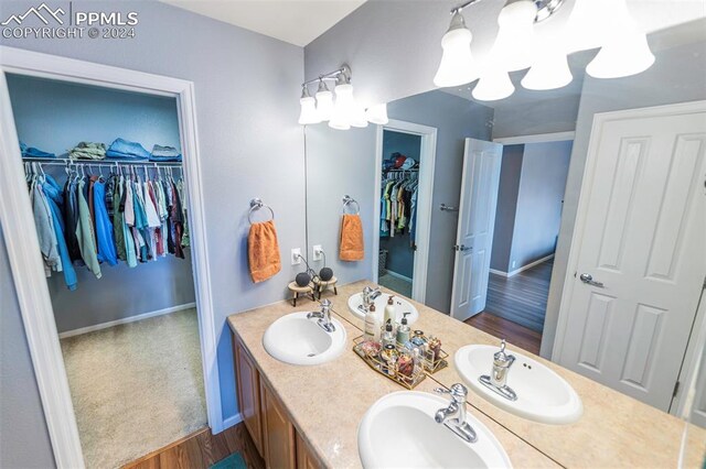 bathroom with dual vanity and wood-type flooring