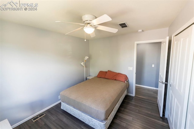 bedroom with ceiling fan, dark wood-type flooring, and a closet