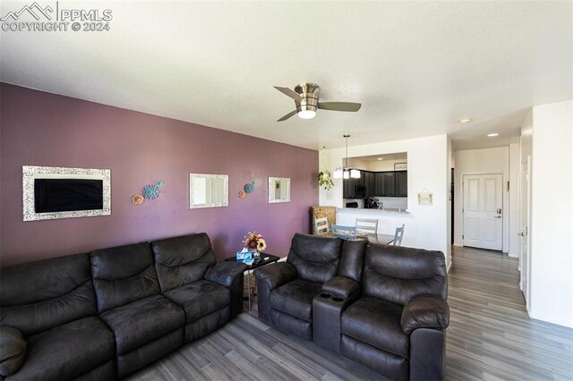 living room with ceiling fan and dark hardwood / wood-style floors