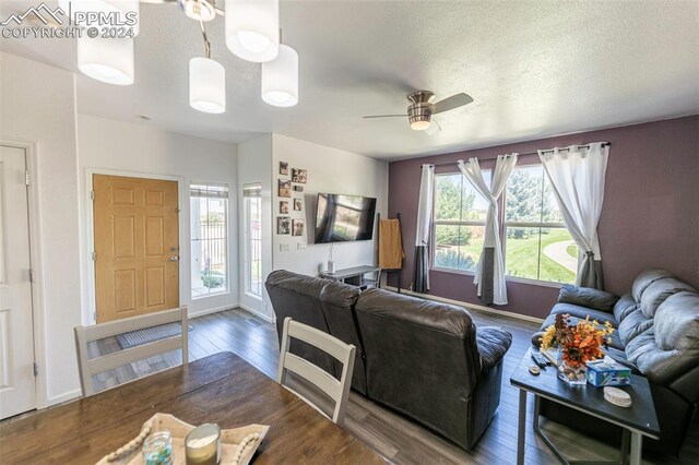 living room featuring a textured ceiling, ceiling fan, and hardwood / wood-style flooring