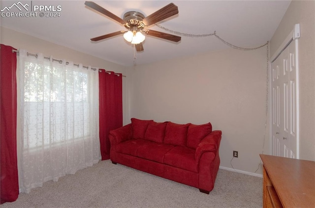 living room with ceiling fan and light colored carpet