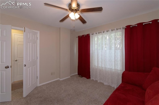 sitting room with ceiling fan and light carpet