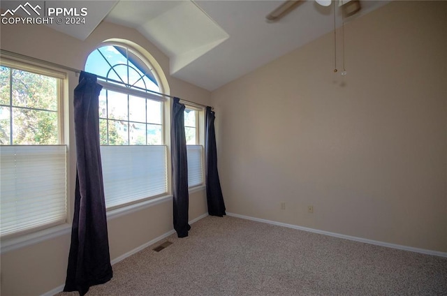 carpeted empty room featuring ceiling fan, plenty of natural light, and vaulted ceiling