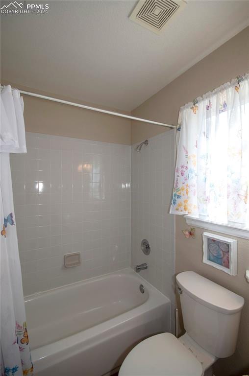 bathroom featuring toilet and tiled shower / bath combo