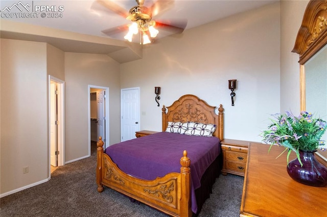 bedroom featuring a spacious closet, dark colored carpet, ceiling fan, and vaulted ceiling