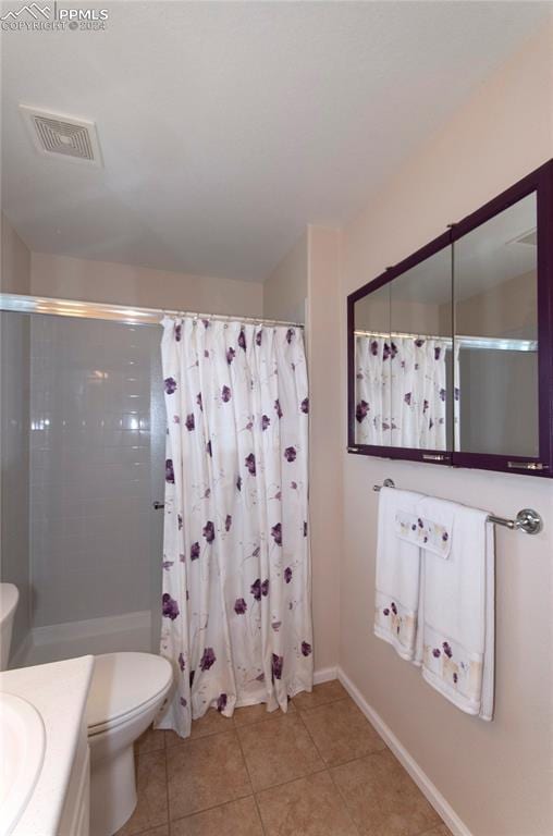 bathroom with tile patterned flooring, a shower with curtain, vanity, and toilet