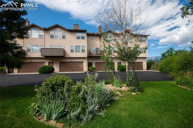 view of front of property featuring a front lawn and a garage