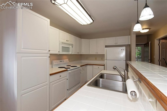 kitchen with sink, pendant lighting, tile countertops, and white appliances