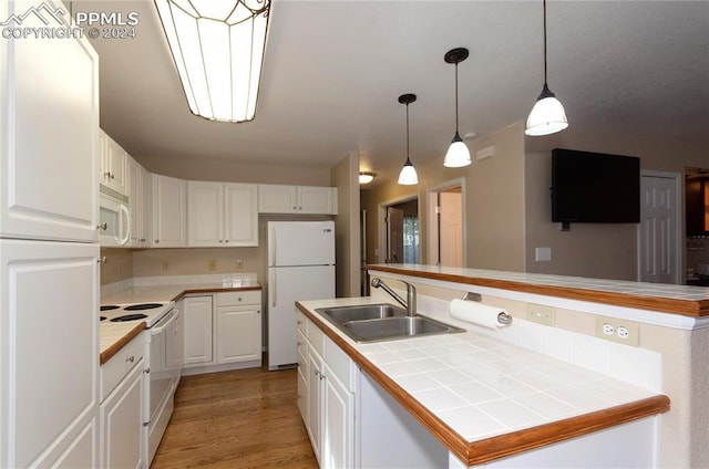 kitchen featuring sink, white cabinets, pendant lighting, tile countertops, and white appliances