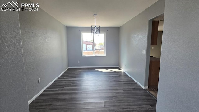 unfurnished dining area with dark wood-type flooring