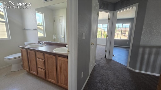 bathroom with vanity, toilet, and hardwood / wood-style flooring