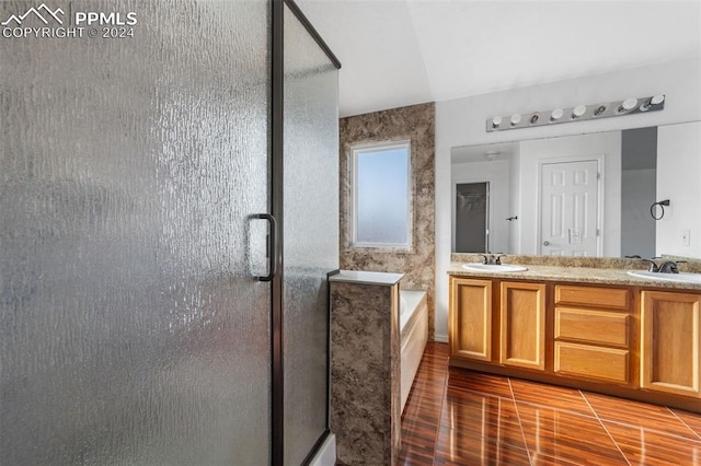 bathroom featuring vanity, wood-type flooring, and separate shower and tub