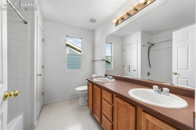 full bathroom featuring vanity, toilet, and tiled shower / bath