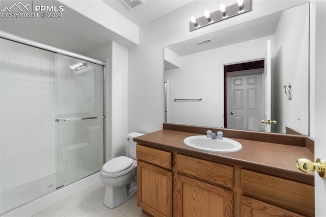 bathroom featuring a shower with door, toilet, and vanity