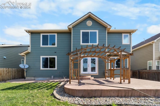 back of property with a pergola, a patio, and a lawn