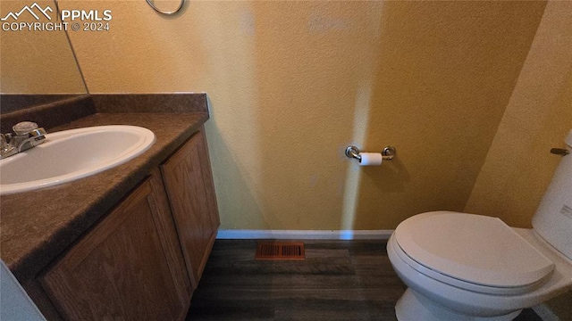 bathroom with vanity, toilet, and wood-type flooring