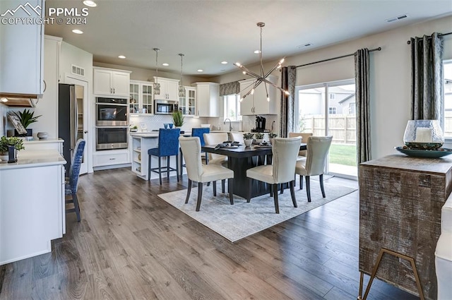 dining space featuring hardwood / wood-style floors, sink, and a notable chandelier