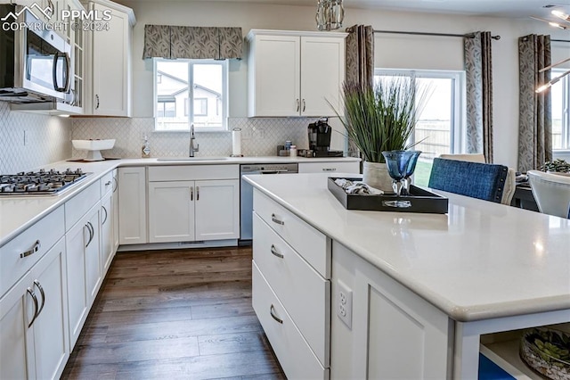 kitchen featuring sink, decorative backsplash, dark hardwood / wood-style floors, stainless steel appliances, and white cabinets