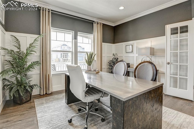 office with hardwood / wood-style floors, ornamental molding, and a healthy amount of sunlight