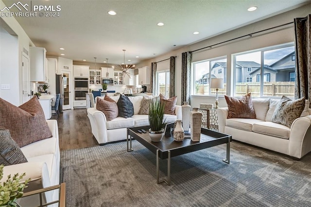 living room with a notable chandelier and dark hardwood / wood-style flooring