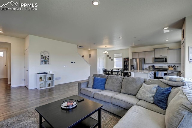 living room featuring dark wood-type flooring and a notable chandelier