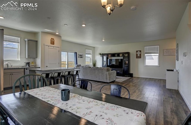 dining area with dark hardwood / wood-style floors and a notable chandelier