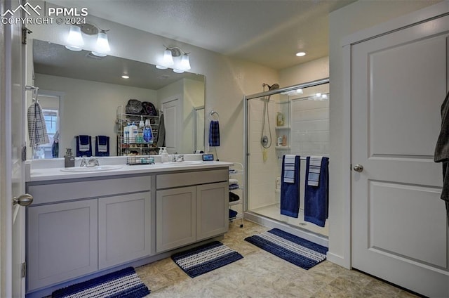 bathroom with tile patterned flooring, double vanity, and a shower with door