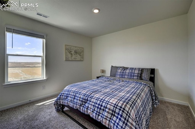 carpeted bedroom featuring visible vents and baseboards