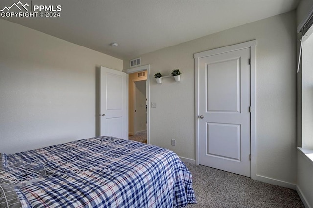 carpeted bedroom featuring baseboards and visible vents