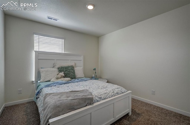 carpeted bedroom with visible vents and baseboards