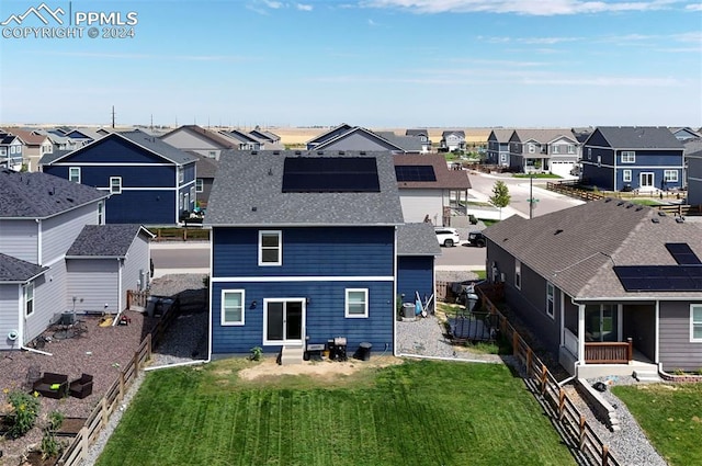 back of property featuring a residential view, a fenced backyard, and a yard