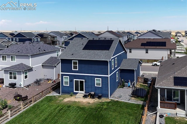 back of house with entry steps, a fenced backyard, a residential view, and a yard