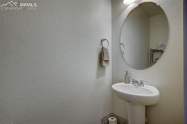 bathroom featuring a textured wall and a sink