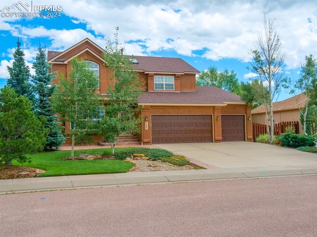 view of front of property featuring a front yard and a garage