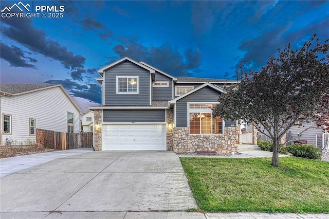 view of front of property featuring fence, an attached garage, concrete driveway, a front lawn, and stone siding