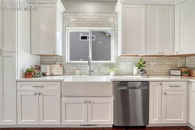 kitchen with a sink, visible vents, stainless steel dishwasher, and light countertops