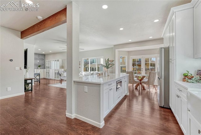 kitchen featuring stainless steel appliances, plenty of natural light, dark wood-style floors, and light countertops