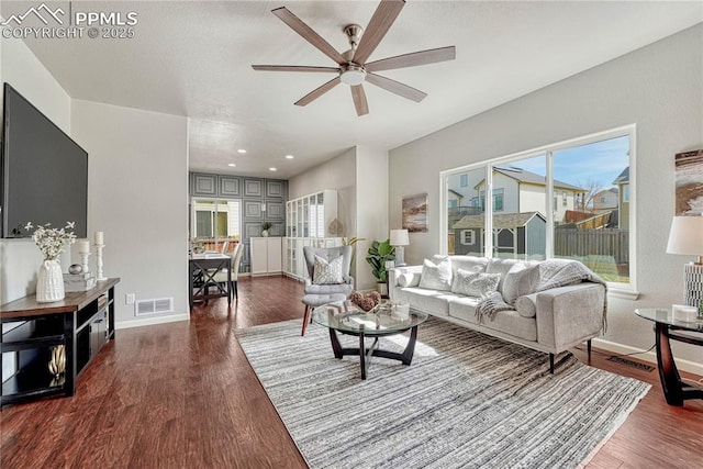 living area featuring wood finished floors, visible vents, and baseboards