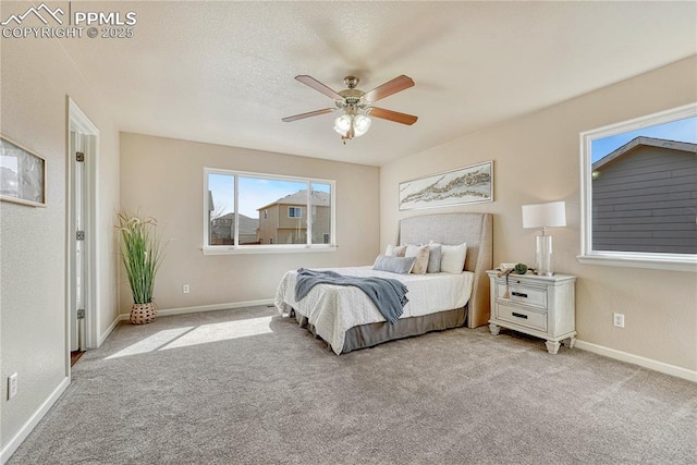 carpeted bedroom featuring a ceiling fan, baseboards, and a textured ceiling